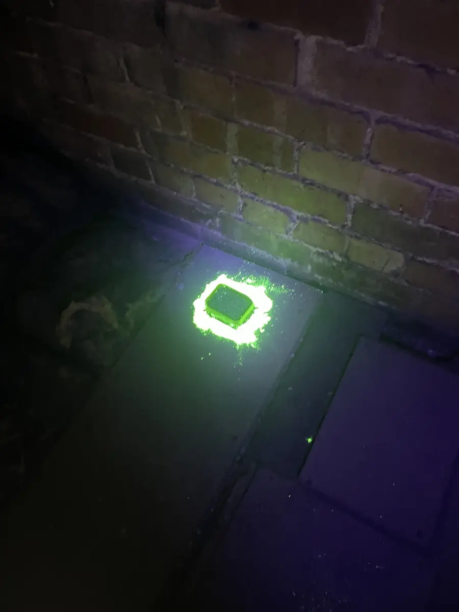 UV tracking product glowing around a small suspected rodent entry point